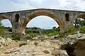 The dry riverbed of the Calavon and the main arch of the bridge