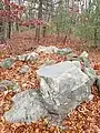 Summit marker embedded in rock with possible remnants of Indian Cairn